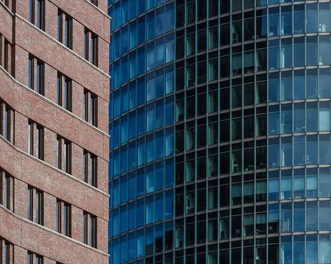 Detail of the Kollhoff-Tower (left) in front of Bahntower (right) at Potzdamer Platz, Berlin, Germany on a summer morning.
