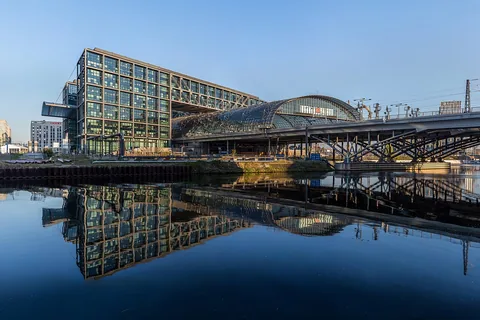 Berlin central station, as seen from south-east. The building is reflecting in the water of the Humboldt harbour. It was built by architect Meinhard von Gerkan of Gerkan, Marg and 