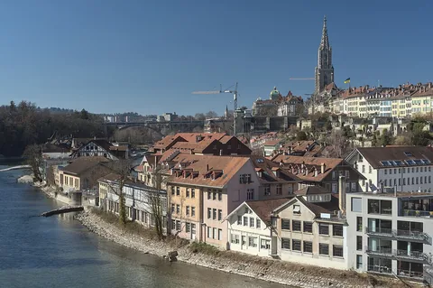 View from the Nydegg Bridge on the southeastern part of the historic old town of Bern. At the top right is the tower of the Berner Münster. In the foreground the river Aare flows a